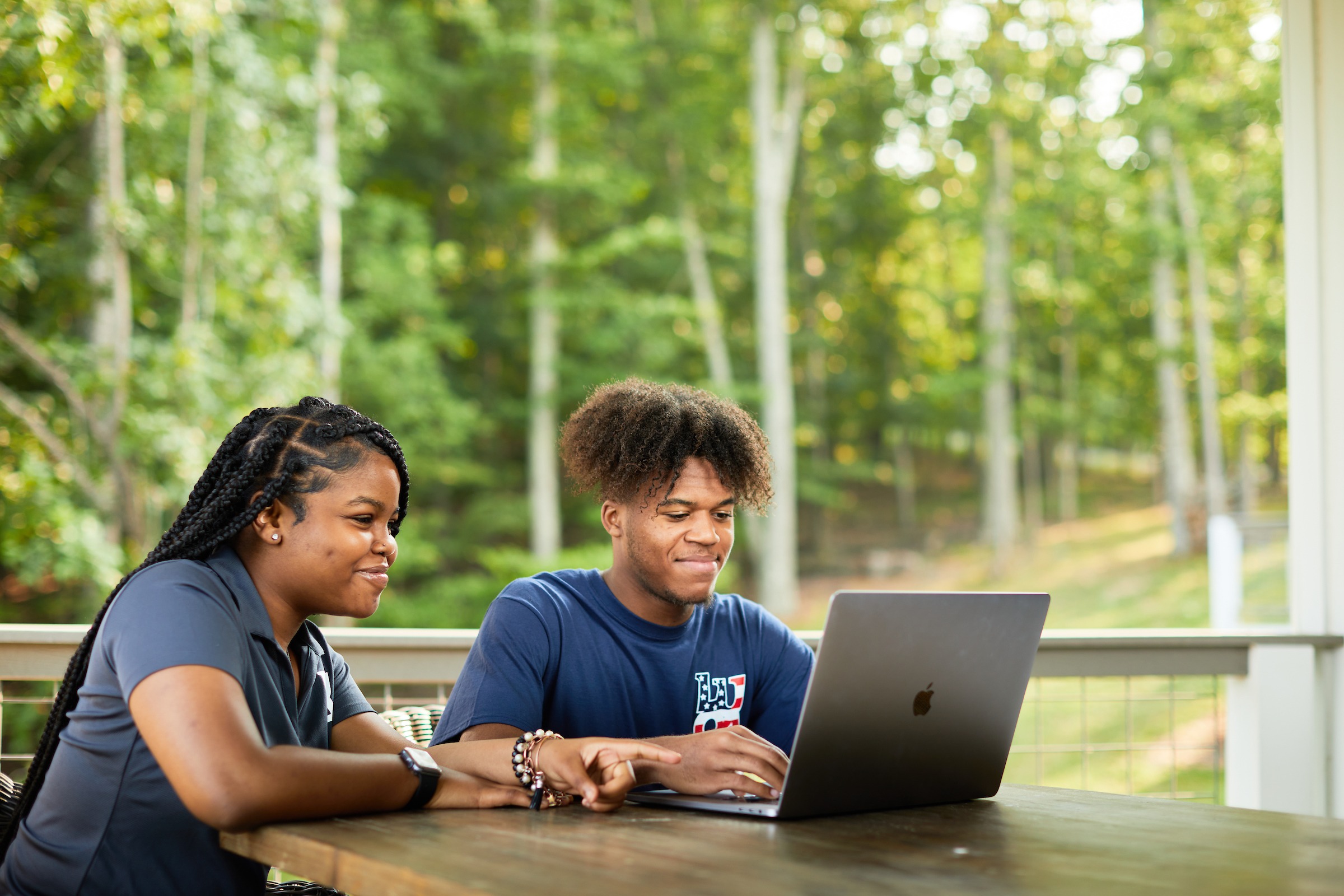 Two LUOA students working on a laptop