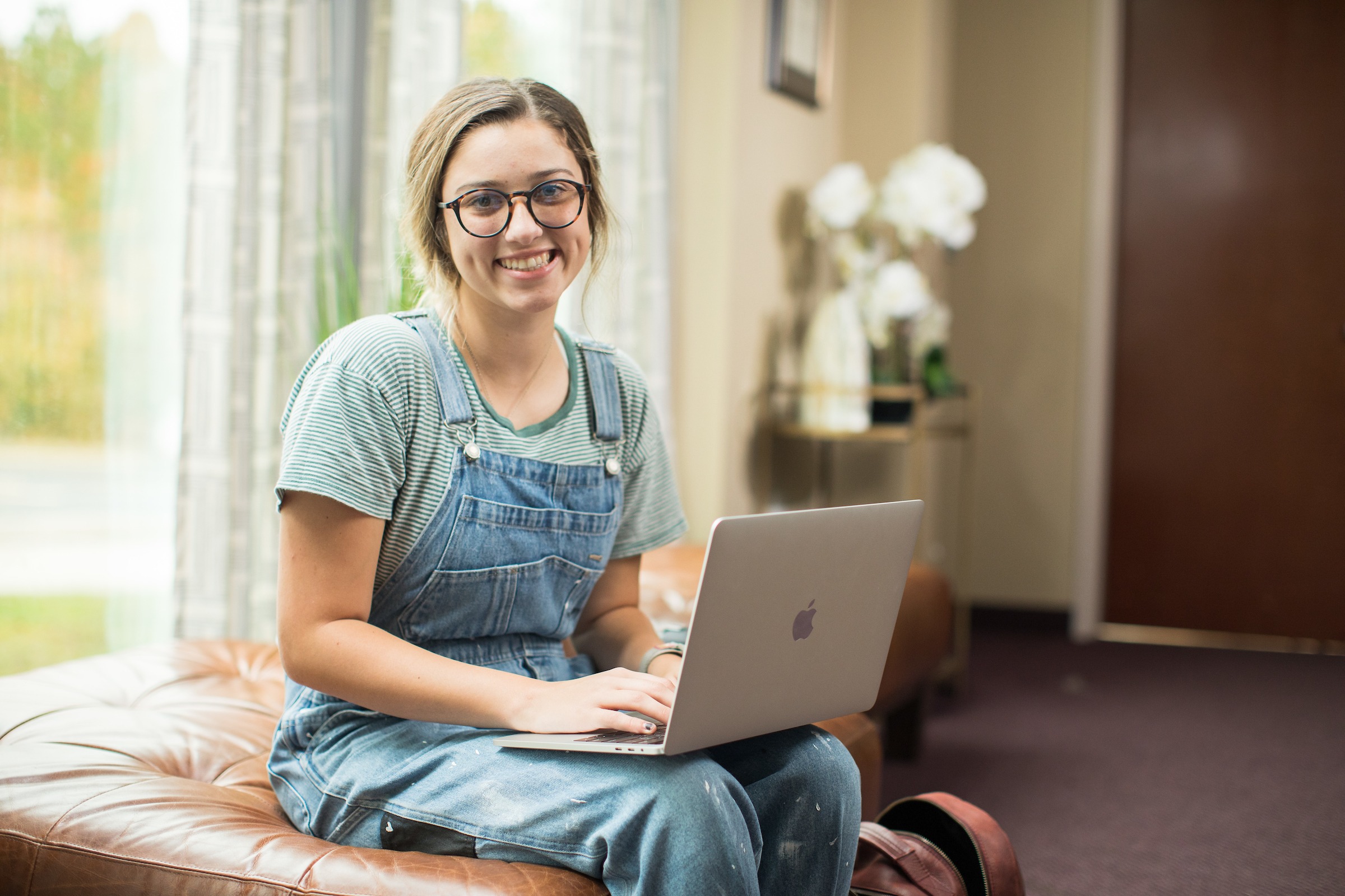 Student on laptop reviewing LUOA accreditation