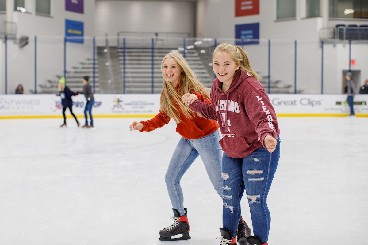 Two girls skating at the LaHaye Ice Center during the LUOA Christmas Party