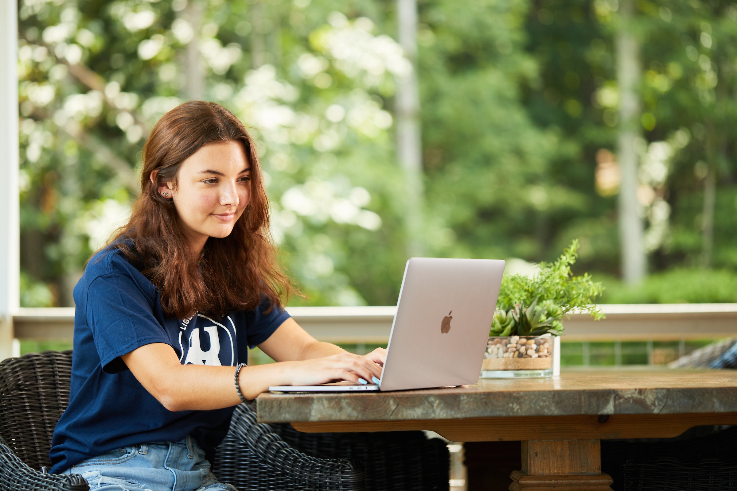 LUOA high school student working outside on laptop