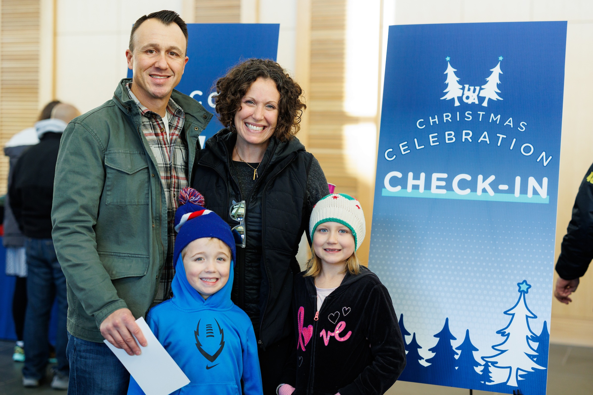 Family smiling while checking in for LUOA's Christmas Celebration