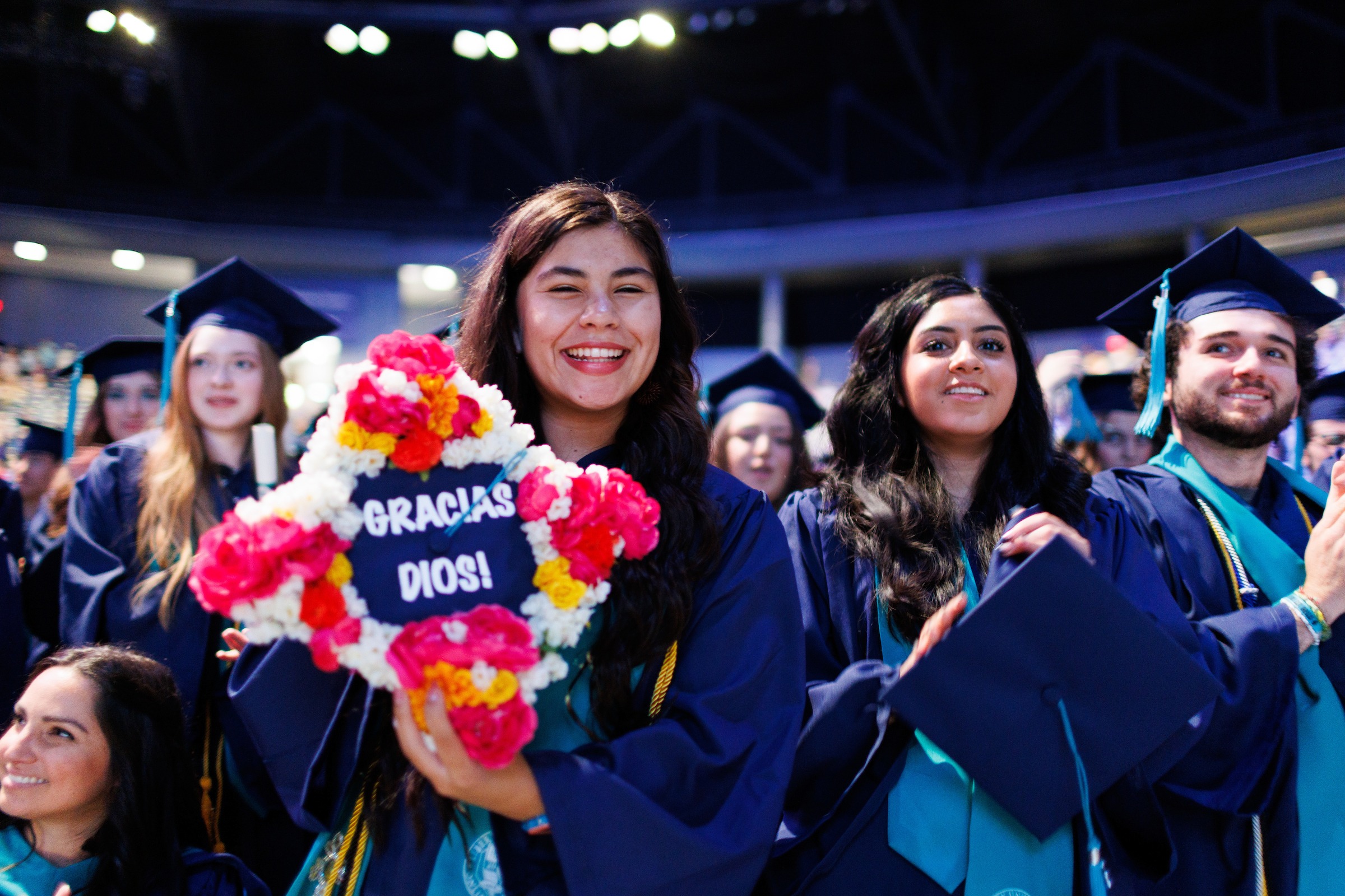 Female LUOA graduate showing her cap decorated with flowers and the words 