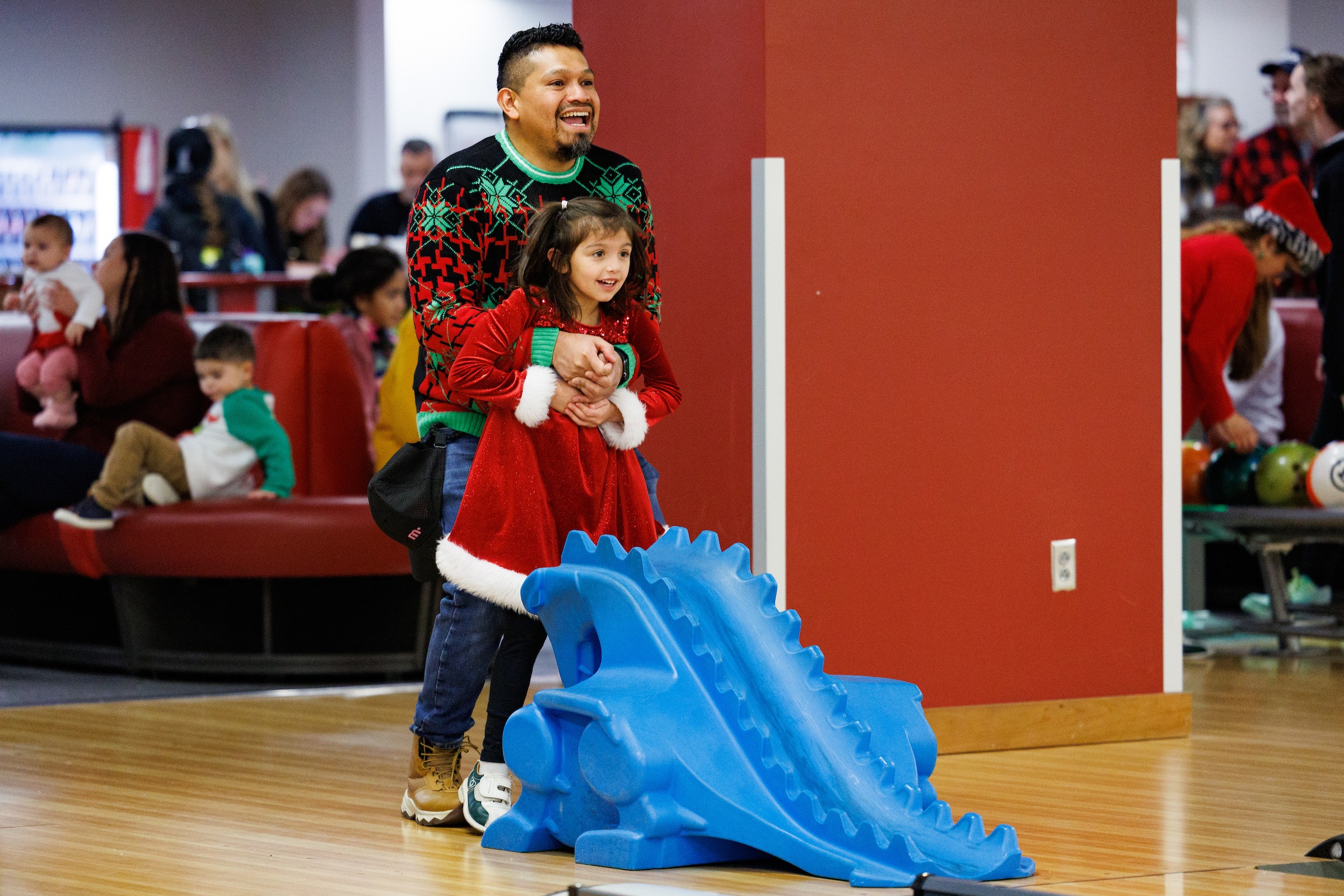 A dad and daughter bowling at the LUOA Christmas Party